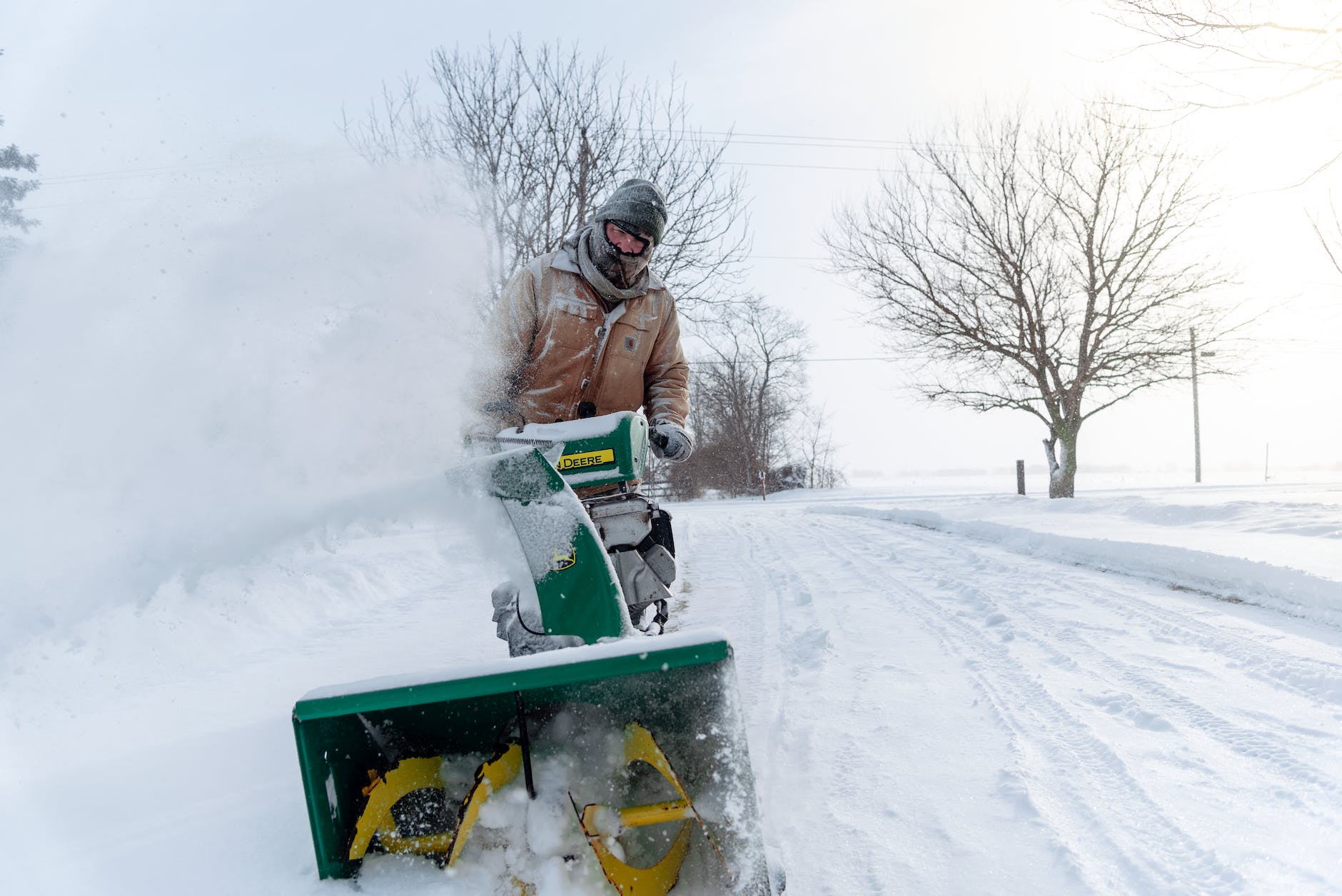 man with snow blower on the road