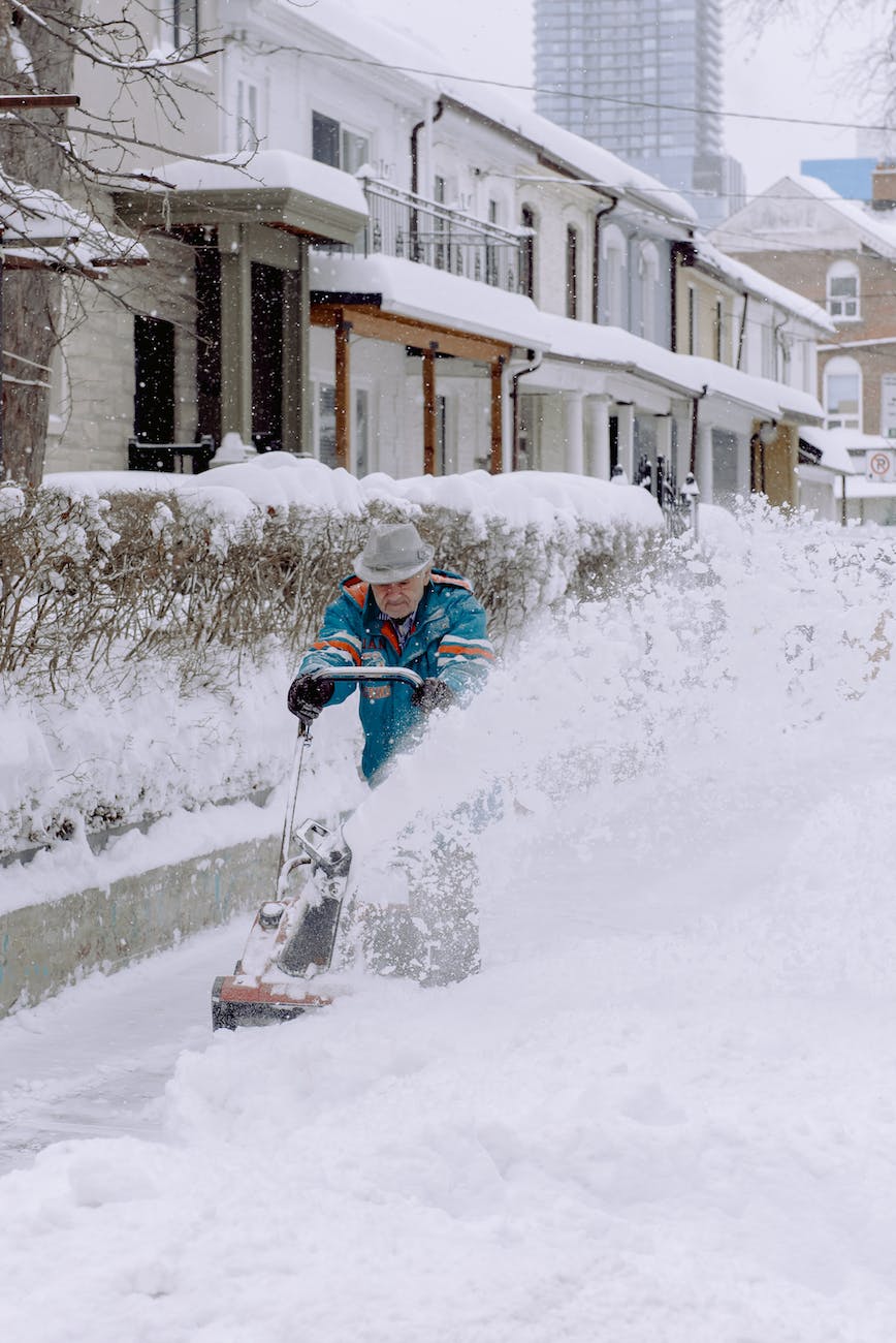 elderly man using snowblower